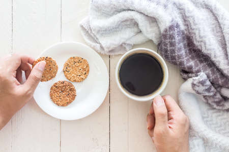 Cup of coffee and scarf on a wooden tableの写真素材