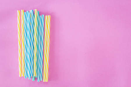 Striped drink straws on pink backgroundの写真素材