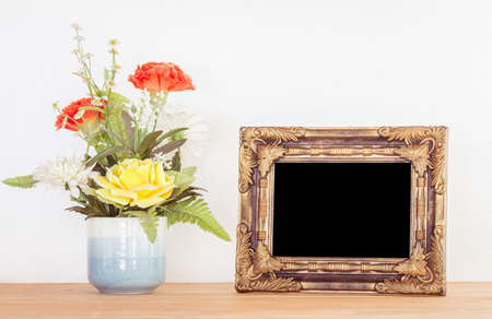 Photo frame and flowers on wooden table