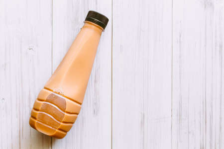 Milk tea in bottle on wooden tableの写真素材