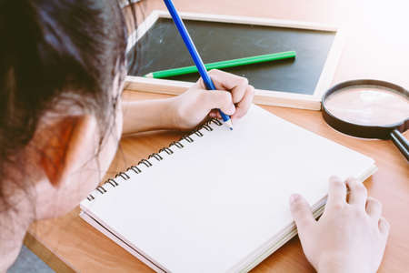 Young girl writing on book