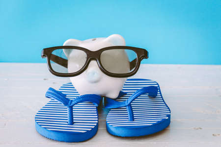 Piggy bank with sunglasses on wooden tableの写真素材
