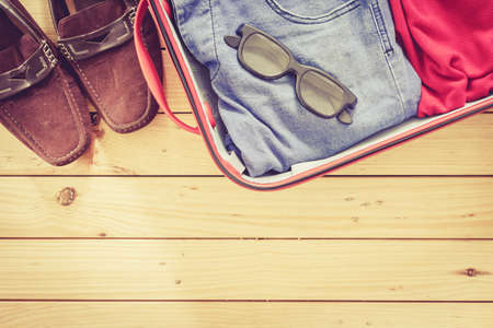 Men's casual  in suitcase on wooden table,Travel Suitcase Man Vacationの写真素材