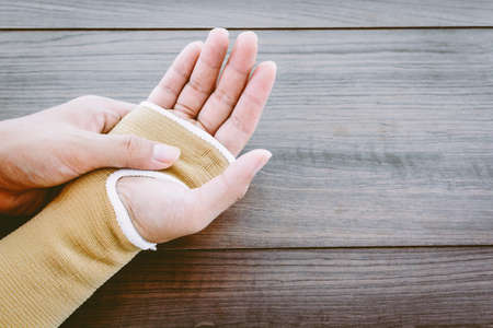 Hand tied bandage on wooden backgroundの写真素材