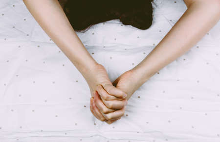 Hand sign orgasm of woman on white bedの写真素材