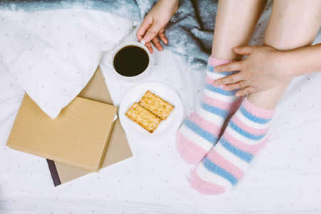 Woman on the bed with cup of coffeeの写真素材