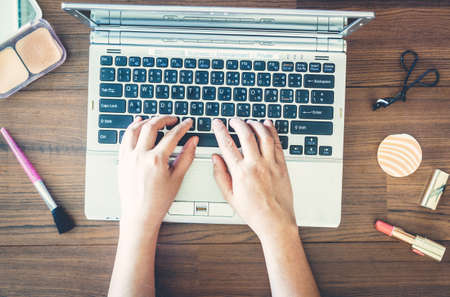 Woman working at office desk with a laptop and woman's accessoriesの写真素材
