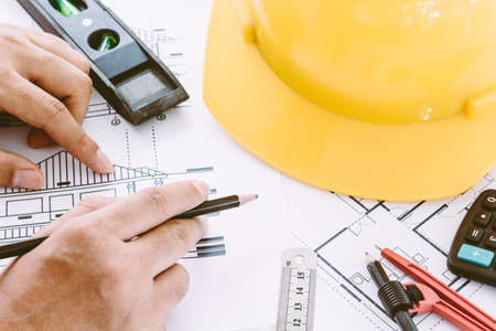Architect working with construction tools and helmet safety on wooden background