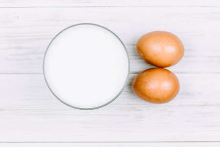 Milk and eggs on wooden backgroundの写真素材