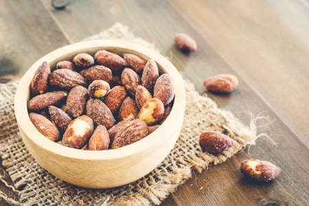 Almonds in bowl on  wooden backgroundの写真素材
