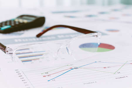 Eyeglasses on business graph information on tableの写真素材