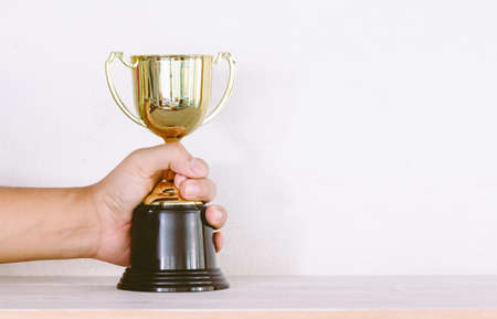 Golden trophy on wooden table with copy spaceの写真素材