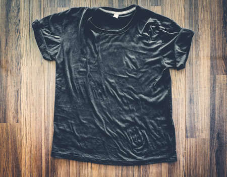 Black t-shirt on wooden backgroundの写真素材