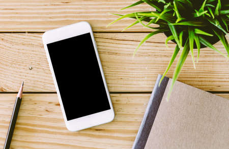 Blank screen smartphone on wooden tableの写真素材