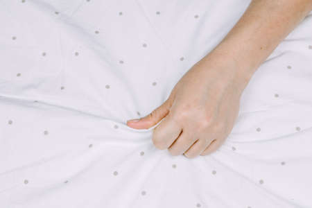 Hand sign orgasm of woman on white bedの写真素材