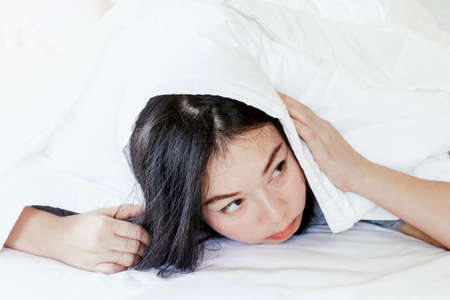 Woman under a duvet  at homeの写真素材