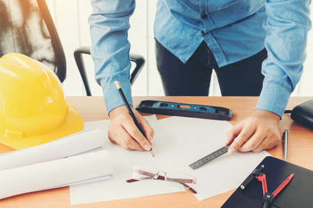 Architect working with construction tools and helmet safety on wooden tableの写真素材
