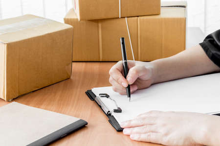 Woman signs clipboard for deliveryの写真素材