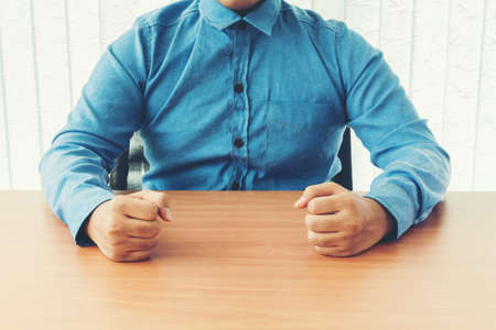 Businessman hand fist on wooden tableの写真素材
