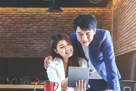 Young couple using tablet computer in coffee shopの写真素材