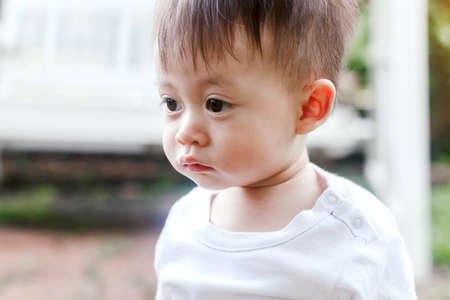 Asian baby boy look somewhere in the parkの写真素材
