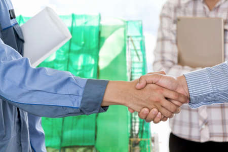 Businessman shaking hands with construction worker