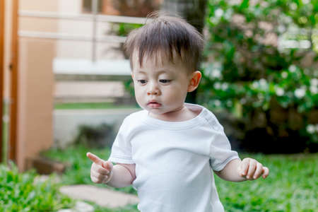 Asian baby boy look somewhere in the parkの写真素材