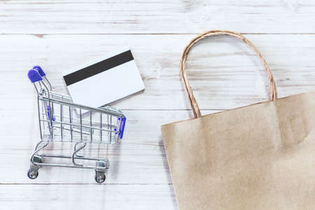 Shopping basket and credit card on wooden background - Online shopping concept