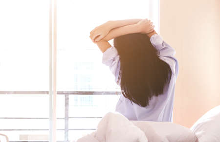 Woman stretching in bed after wake up