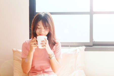 woman drinking coffee on bed