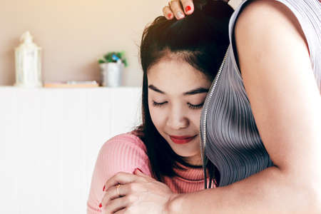 Mother and teen daughter receiving a hugの写真素材