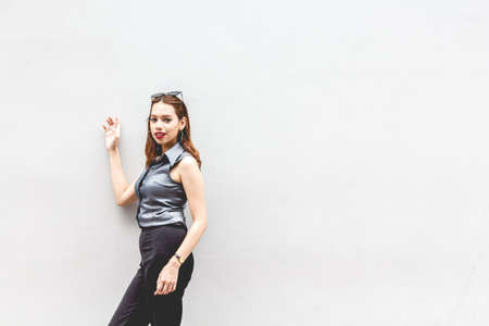 Fashion image of fashionable beautiful woman on wall backgroundの写真素材