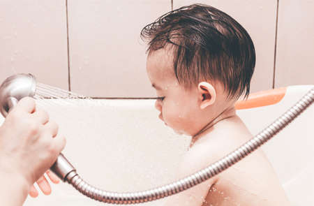 Mother washing shower with baby in bathの写真素材
