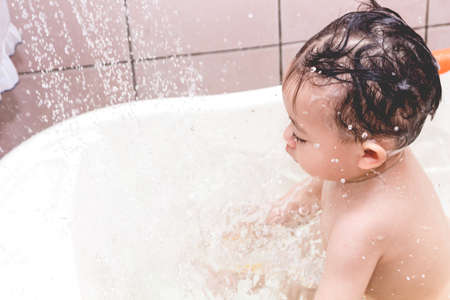 Mother washing shower with baby in bathの写真素材