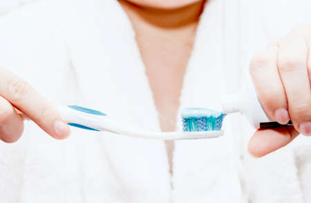 Woman applying toothpaste on toothbrush