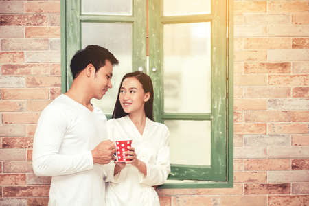 Young couple drink coffee together at homeの写真素材