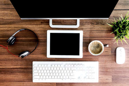 Computer with tablet and working place on wooden table