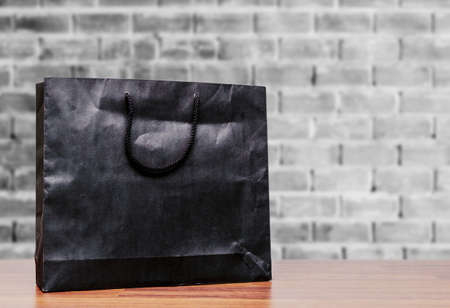 Black paper shopping bag on wall backgroundの写真素材