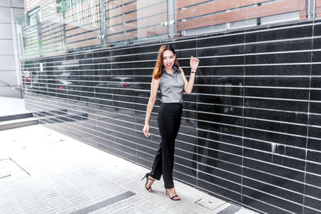 Fashion young woman walking on the streetの写真素材