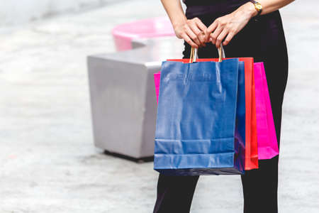 Woman holding shopping bag walking on the streetの写真素材