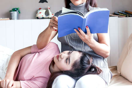 Mother and teenage daughter smiling at homeの写真素材