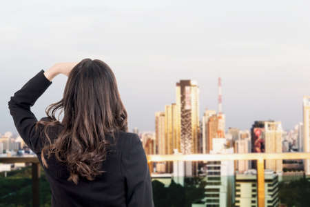 Business woman stand and look something on blur city backgroundの写真素材
