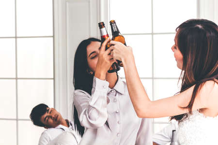 Two female friends enjoying drinking beerの写真素材