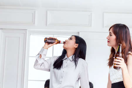 Two female friends enjoying drinking beerの写真素材