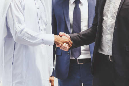 Successful businessmen handshake partner with arab businessmanの写真素材