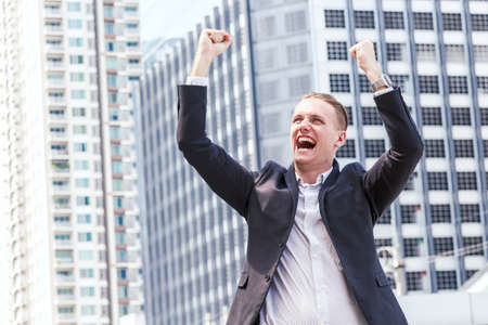 Successful businessman celebrating with arms upの写真素材