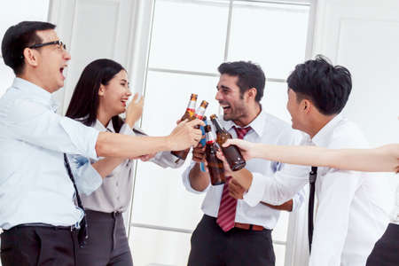 Group of business people professionals successful drink beers in officeの写真素材