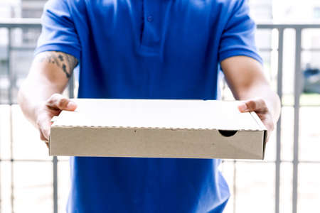 Delivery man holding boxes with pizza