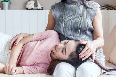 Mother and teenage daughter smiling at homeの写真素材