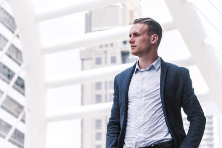 Portrait of handsome man in black suit standing outdoorsの写真素材
